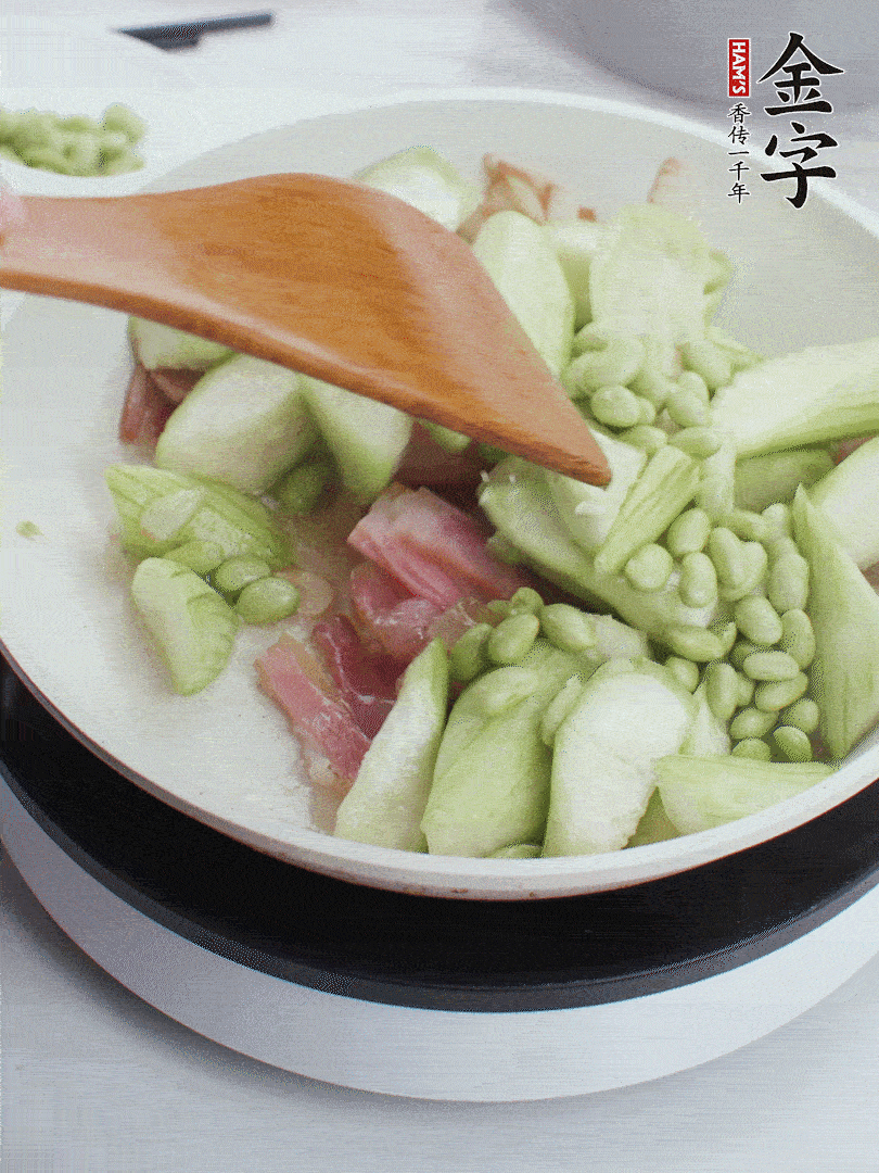 依次下丝瓜、青豆翻炒，炒至丝瓜打蔫缩小。