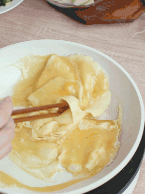 油6成热时，下鸡蛋液，边缘凝固时翻拌成块状。