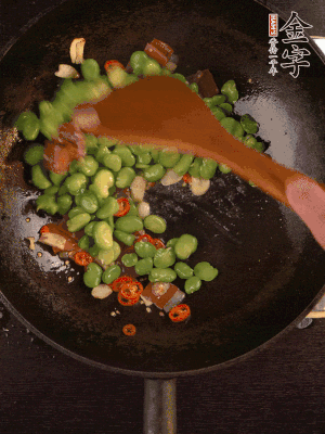 再下蚕豆煸炒，加1勺料酒调味。