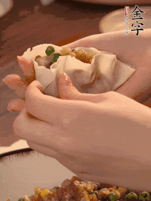 取一大勺馅料放进饺子皮里，用大拇指按住顶部馅料，再用虎口掐出形状。
