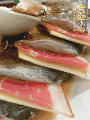 鱼肚中塞葱结、火腿片，鱼身上码放姜片、火腿片，倒入混合的料汁。