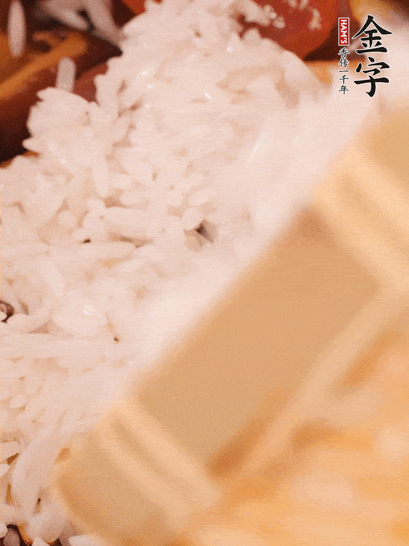 接着倒入提前浸泡的大米，加生抽、食盐、白胡椒粉，一起翻炒均匀。