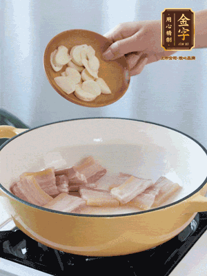 热油下咸肉煸出香味，加蒜片、毛豆翻炒均匀